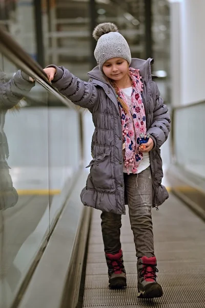 Little girl on moving staircase — Stock Photo, Image