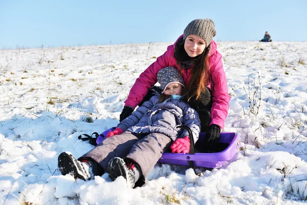 Little girl enjoying a sleigh ride whith mother — Stock Photo, Image