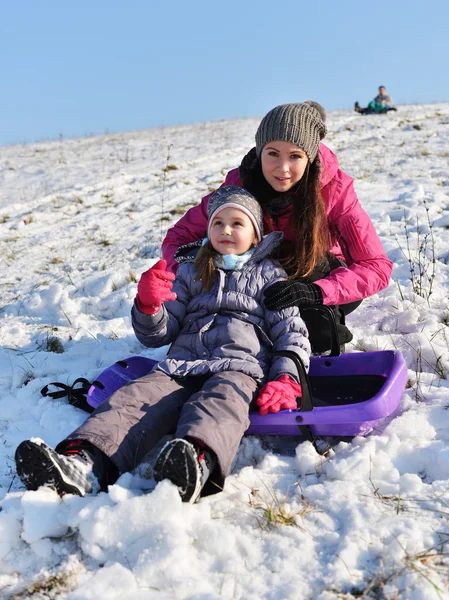 Little girl enjoying a sleigh ride whith mother — Stock Photo, Image