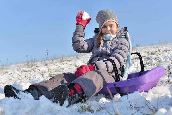 Kleines Mädchen genießt eine Schlittenfahrt. — Stockfoto