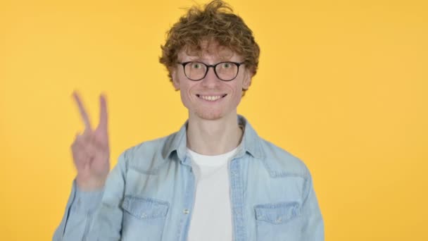 Victory Sign by Redhead Young Man, Yellow Background — Stock Video