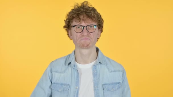 Rotschopf junger Mann mit gesenktem Daumen, gelbem Hintergrund — Stockvideo