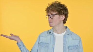 Kopyalama alanı, Kızıl saçlı genç adam Elde Ürün Gösteriyor, Sarı Arkaplan