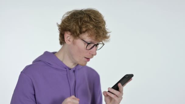 Éxito en Smartphone por Redhead Young Man, fondo blanco — Vídeos de Stock