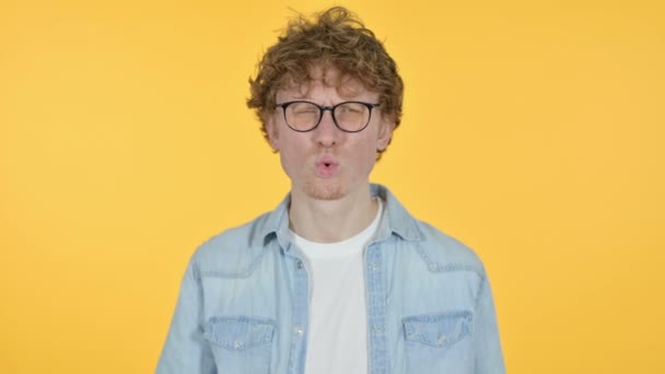 Müder Rotschopf, junger Mann mit Nackenschmerzen, gelber Hintergrund — Stockvideo