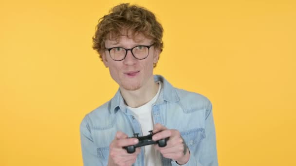 Rossa giovane uomo giocare video gioco, sfondo giallo — Video Stock