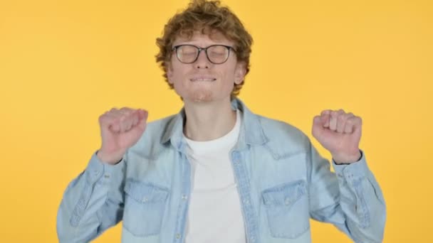 Spännande rödhårig ung man dansar, gul bakgrund — Stockvideo