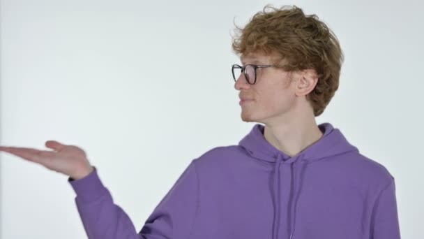 Fénymásolás hely, vörös hajú fiatal férfi megjelenítése termék kéznél, fehér háttér — Stock videók