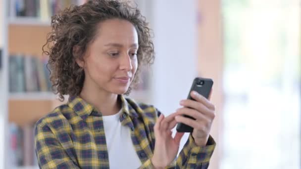 Portret van de gemengde vrouw van het ras te vieren op de smartphone — Stockvideo