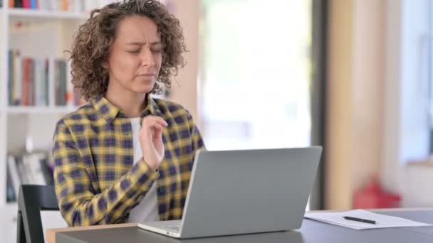 Jonge gemengde ras vrouw met nek pijn met behulp van laptop op het werk — Stockvideo