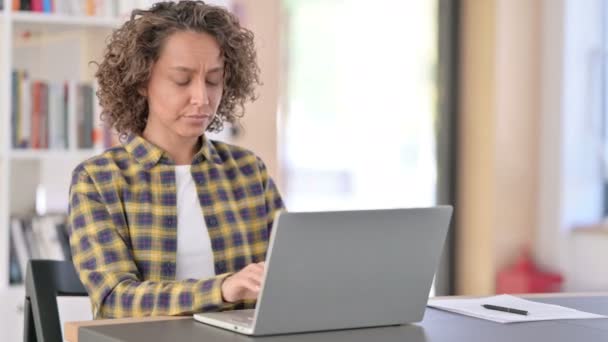 Femme de race mixte fatiguée avec douleur au dos en utilisant un ordinateur portable au travail — Video