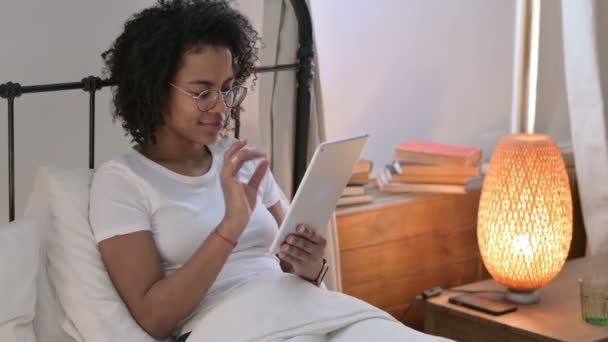 Atrakcyjna młoda Afrykanka korzystająca z tabletu w łóżku — Wideo stockowe