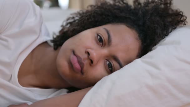 Primer plano de la joven africana mirando a la cámara en la cama — Vídeos de Stock