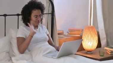 Yataktaki Genç Afrikalı Kadın 'ın Dizüstü bilgisayardaki video çağrısı 