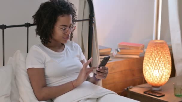 Uso de Smartphone por Young African Woman en la cama — Vídeo de stock