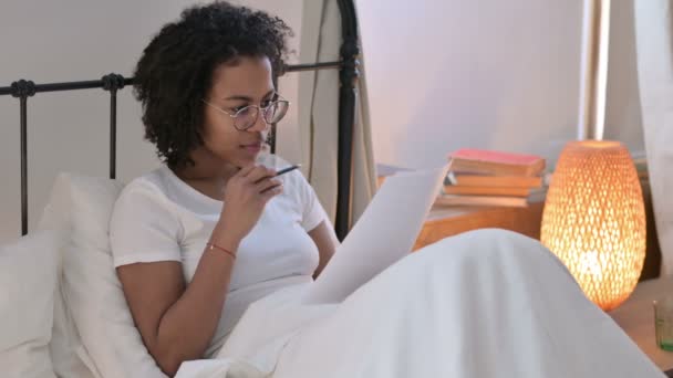 아프리카의 젊은 여성이 침대에서의 문서의 성공을 기념하다 — 비디오