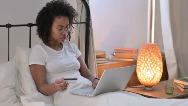 Compras en línea Éxito en el ordenador portátil por la mujer africana joven en el sofá — Vídeo de stock