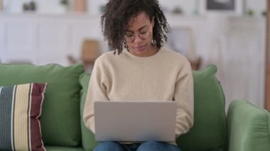 Sofrada dizüstü bilgisayar kullanan güzel bir Afrikalı kadın. 