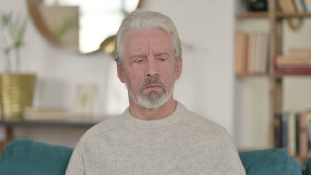 Porträt eines traurigen alten Mannes, der zu Hause in die Kamera schaut — Stockvideo