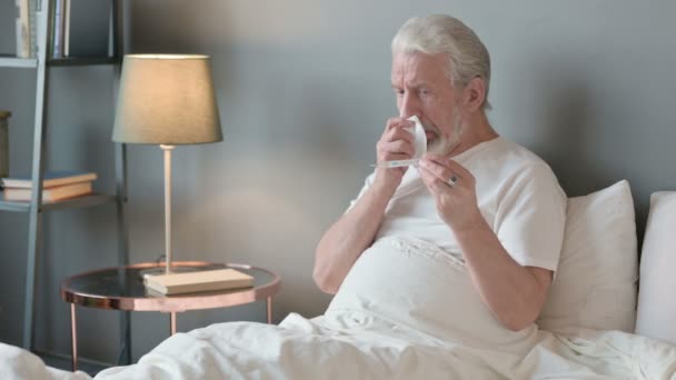 Anciano mayor estornudo Comprobación de temperatura en la cama, termómetro — Vídeos de Stock