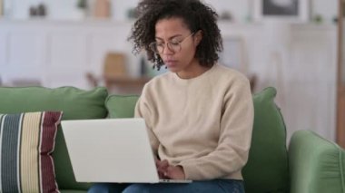 Dizüstü bilgisayarlı genç Afrikalı Kadın Koltukta Sırt Ağrısı Var 