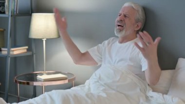 Kızgın yaşlı adam yatakta hayal kırıklığı yaşıyor. 