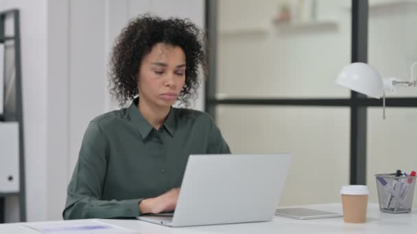 Mujer africana tosiendo mientras usa el ordenador portátil en el trabajo — Vídeos de Stock