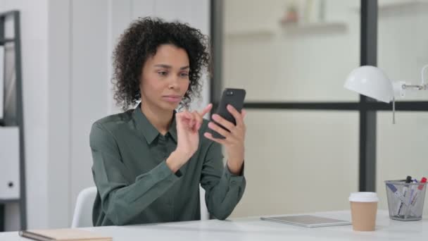 African Woman świętuje sukces podczas korzystania ze smartfona — Wideo stockowe