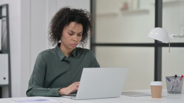 Afrikaanse vrouw met rugpijn tijdens het gebruik van laptop — Stockvideo