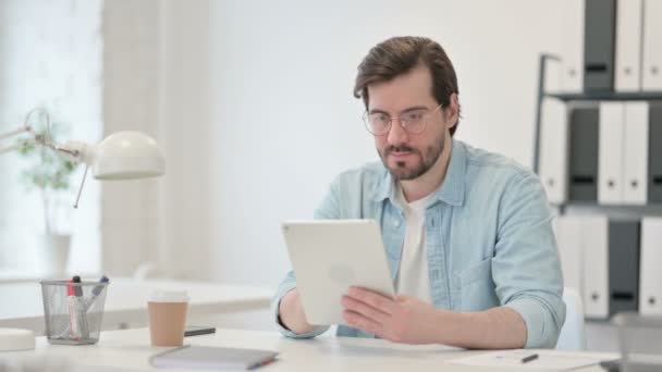 Mladý muž používající tablet v práci — Stock video