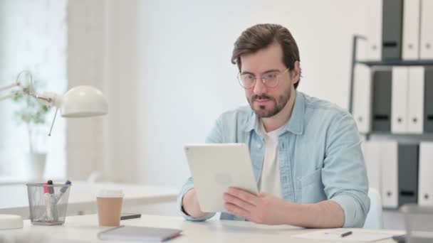 Joven usando la tableta en el trabajo — Vídeos de Stock