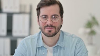 Kameraya gülümseyen genç adamın portresi 