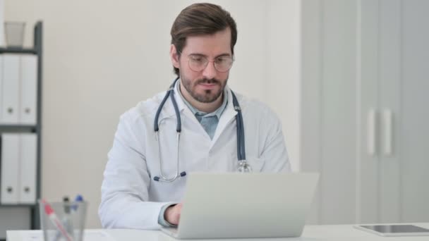 Young Male Doctor with Laptop Smiling at Camera — Stock Video