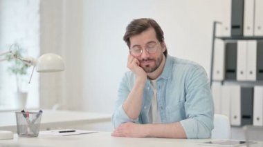 Uykulu genç adam iş yerinde kestiriyor. 