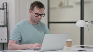 Laptop 'ta görüntülü sohbet yapan genç adam 