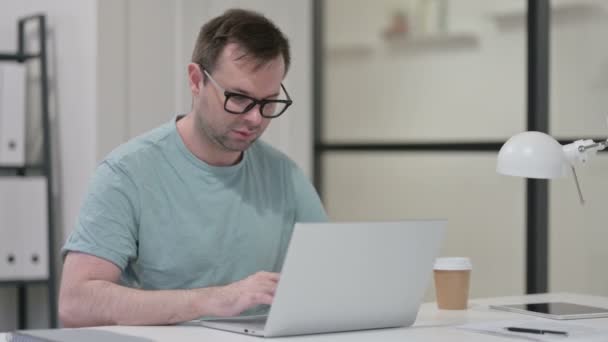 Jongeman met nekpijn tijdens het werken op laptop — Stockvideo