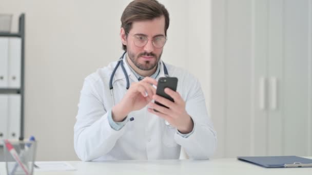 Unge mandlige læge ved hjælp af Smartphone på arbejdspladsen – Stock-video