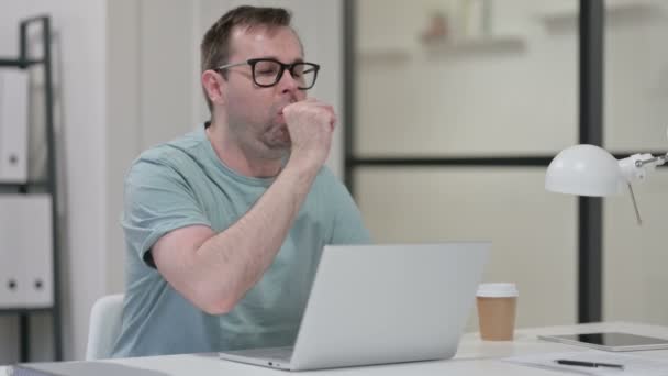 Junger Mann hat Husten, während er am Laptop arbeitet — Stockvideo
