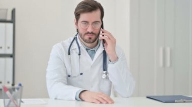 Genç Erkek Doktor İş yerinde Akıllı Telefonla Konuşuyor 