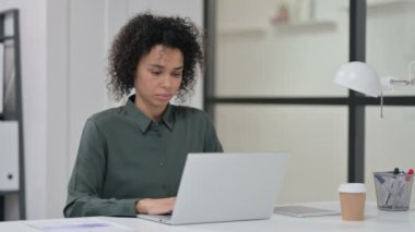 Dizüstü bilgisayarlı genç Afrikalı Kadın Kameraya Gülümsüyor 