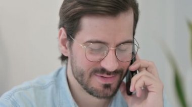 Akıllı telefondan konuşan genç adama yaklaş. 
