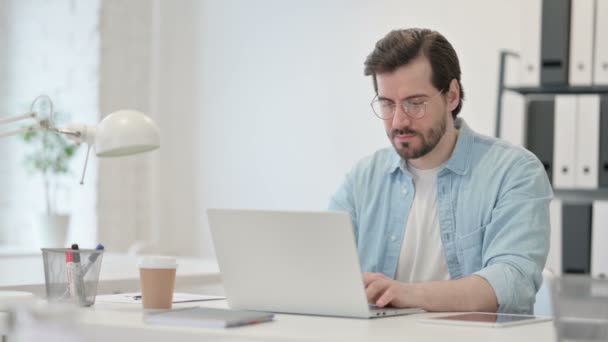 Młody człowiek z bólem nadgarstka pracuje na laptopie — Wideo stockowe