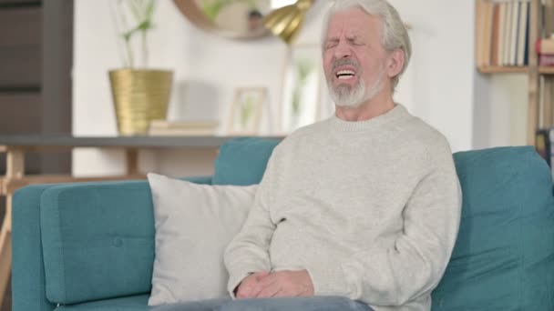 Müder alter Mann mit Rückenschmerzen auf dem Sofa — Stockvideo