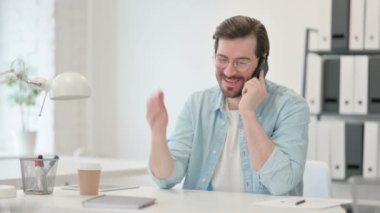 Genç Adam İş yerinde Akıllı Telefonla Konuşuyor 
