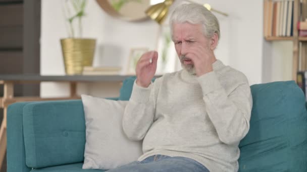 Hombre viejo estresado con dolor de cabeza en el sofá — Vídeos de Stock