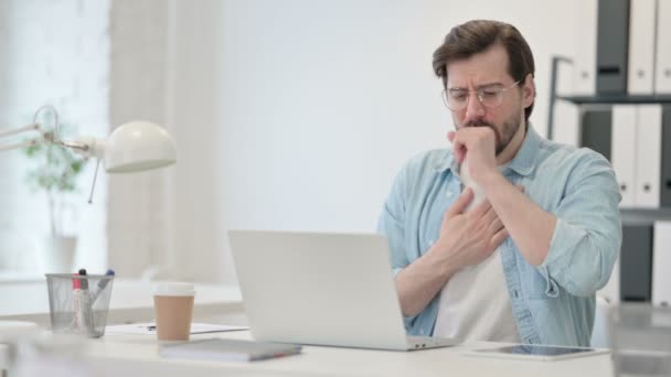 Jeune homme avec ordinateur portable tousse au travail — Video