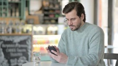 Akıllı telefon kullanırken kutlama yapan genç adam