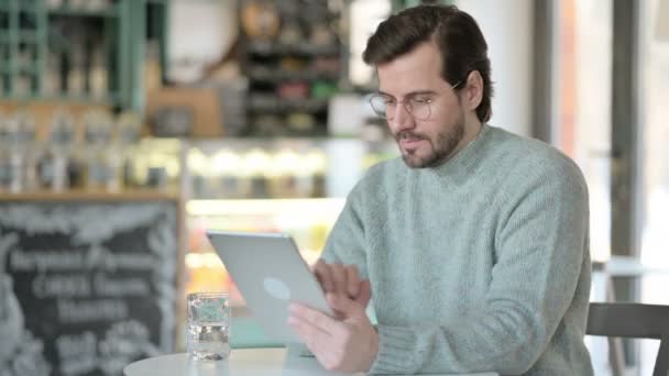 Młody człowiek za pomocą tabletu w Cafe — Wideo stockowe