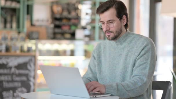 Young Man with Laptop Smiling at Camera in Cafe — Stock Video