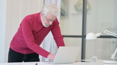 Yaratıcı Yaşlı Adam Dizüstü bilgisayarda ayakta duruyor ve çalışıyor 